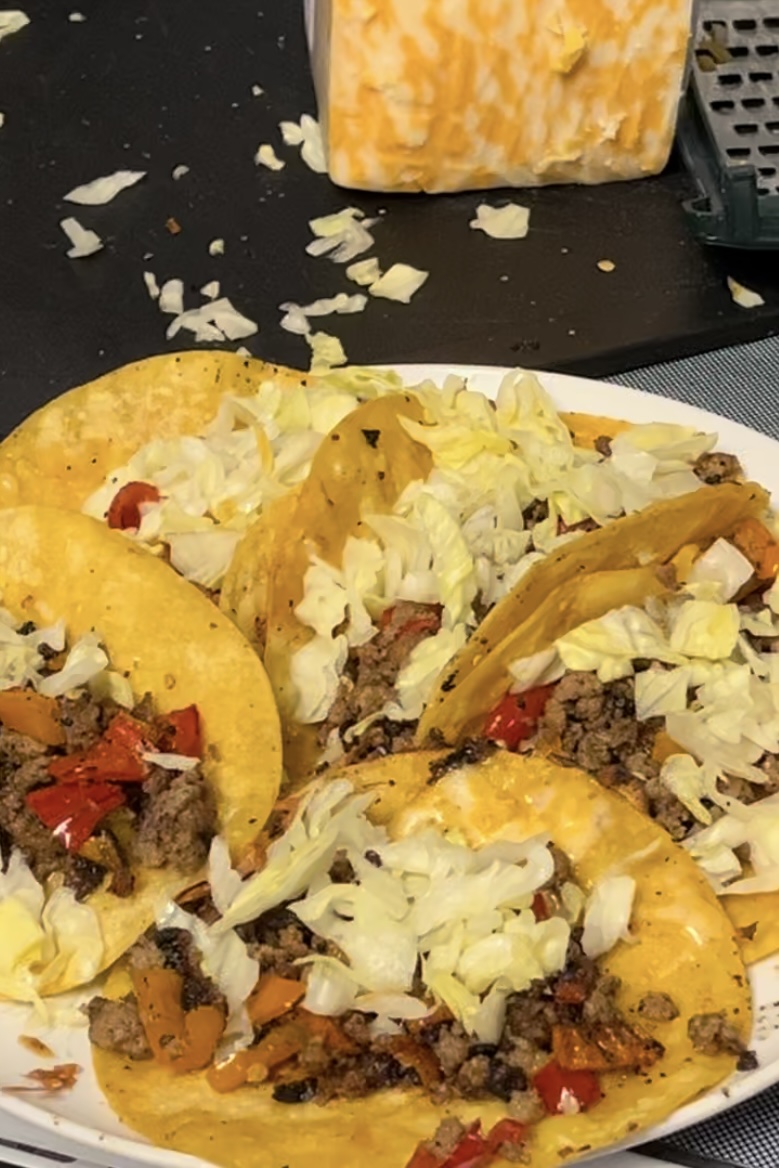 Tortillas have been pulled out the pan and at least six are sitting on a plate with meat and been peper and then lettus on them
