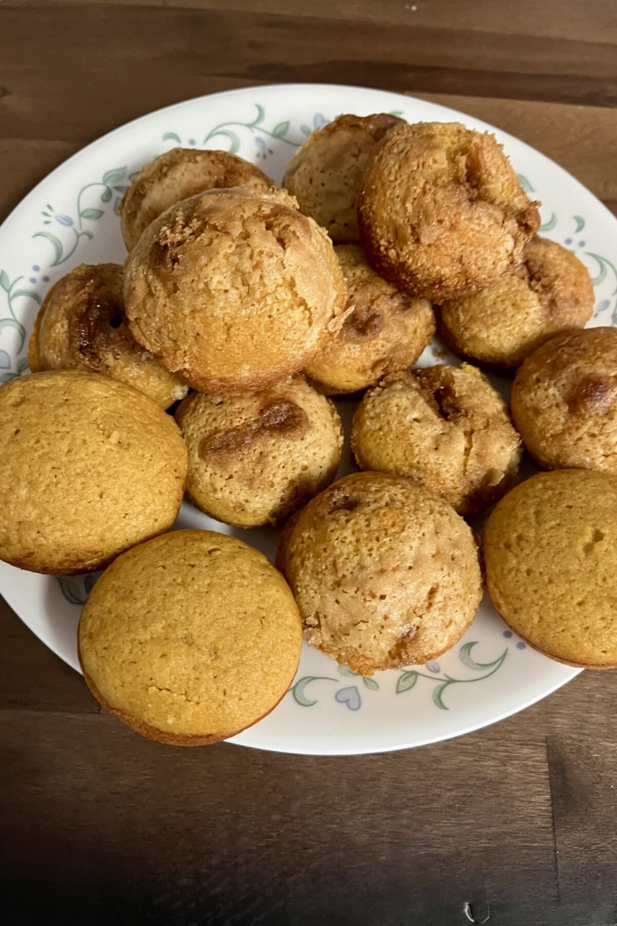 Pumpkin muffins have been put on a plate kind of in a circular pattern some stacked on each other about half of them. We did had a little bit of cinnamon sugar and sugar too. Extra design