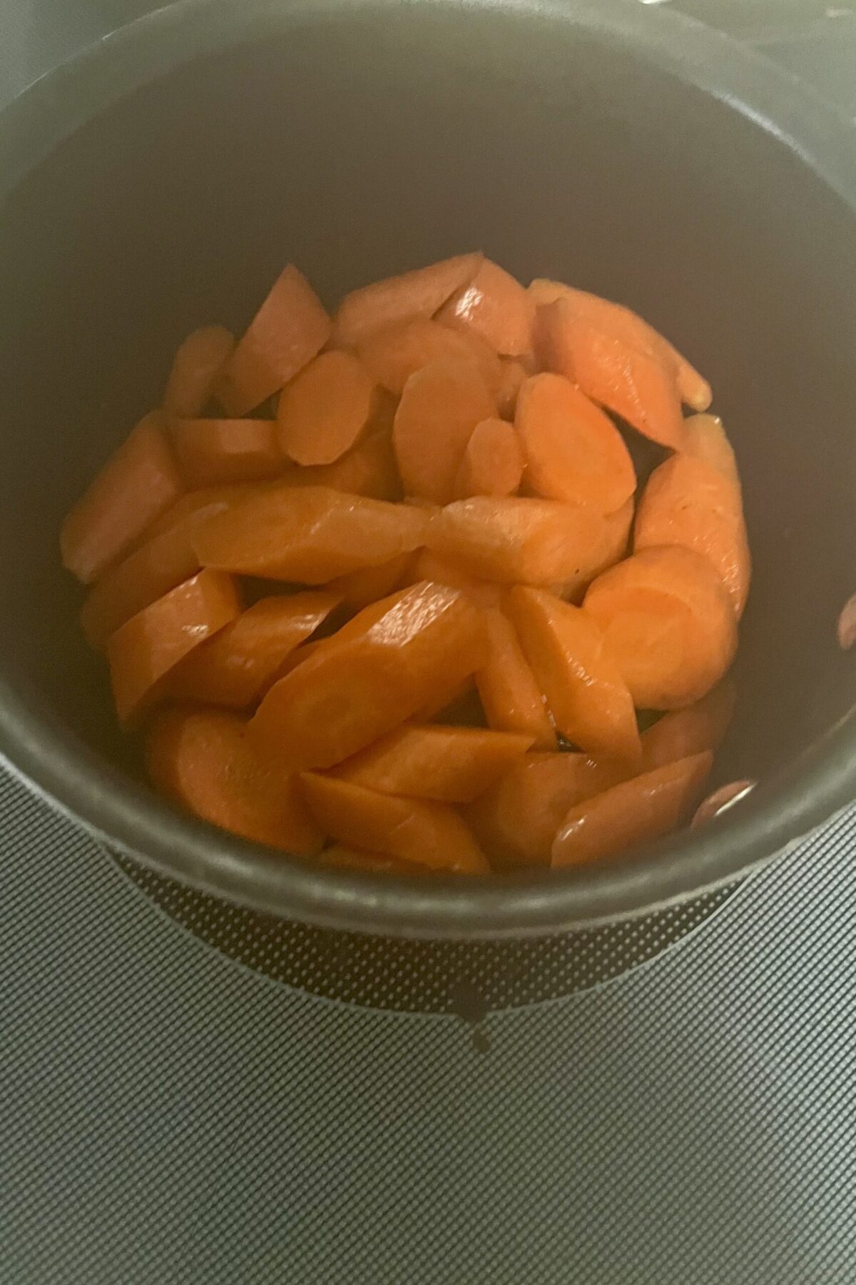 Carrots that have been cut out an angle and now cooking in a pot
