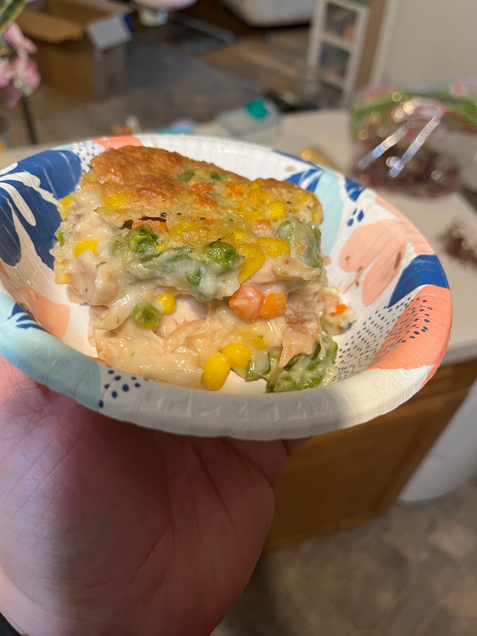 Some chicken cowboy burger that’s been served up into a bowl bowl has a little blue flowers on it square piece you can see a nice crust on the top and kind of see a chicken lay on the bottom and then a mixture of green beans carrots corn