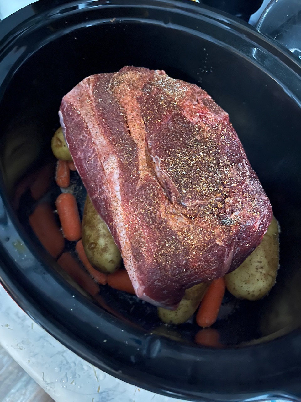 Potatoes have been added to the crockpot along with carried throat has been along with seasoning
