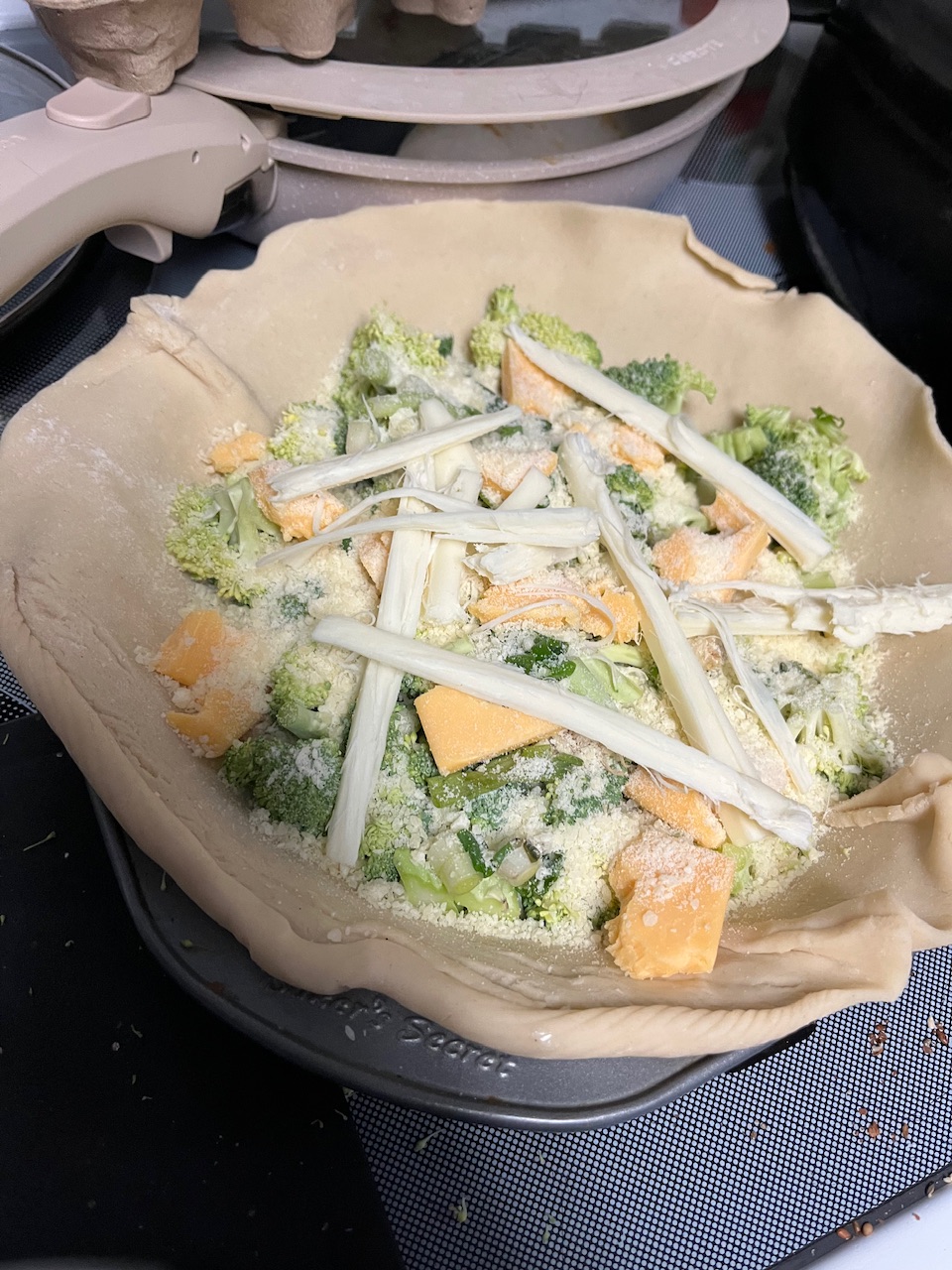 Covered in cheese as a combination of ground Parmesan cheese and some mozzarella from a cheese stick that’s just been pulled into pieces and laid on top