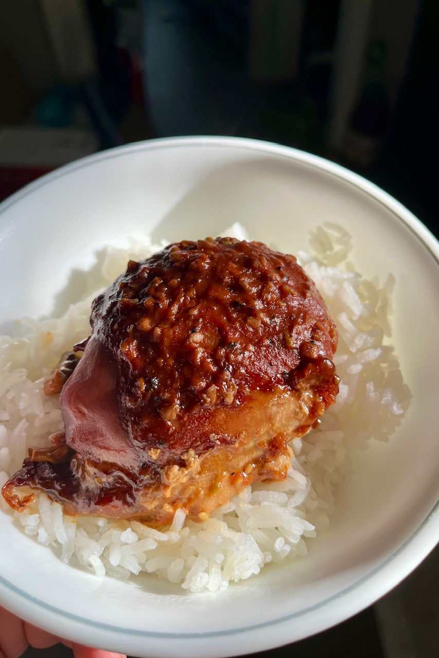 Chicken has been placed on a beer of rice has a nice dark red color