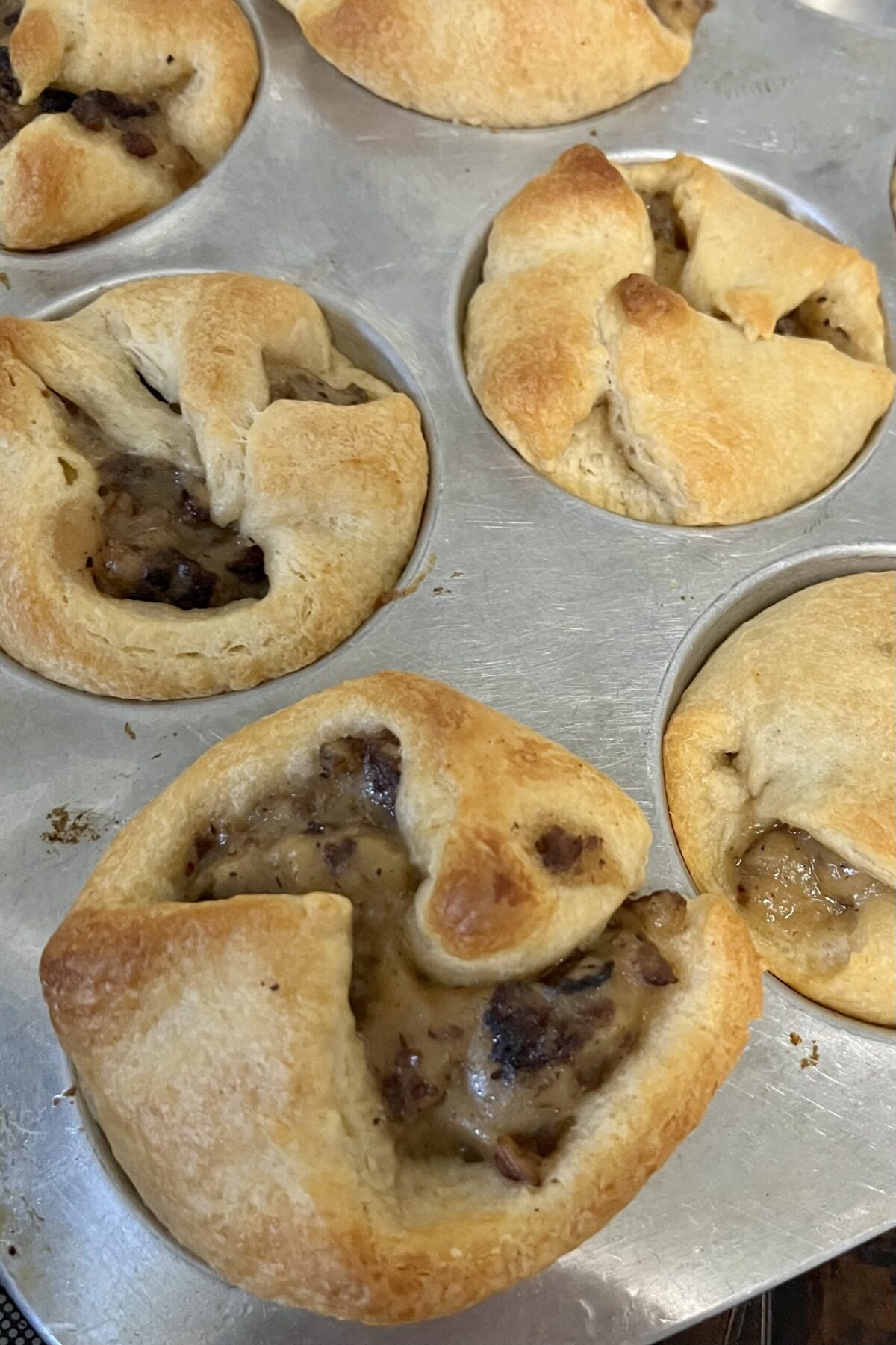 Crescent rolls have been cooked and shave a nice fat gold color and wrapped sausage gravy