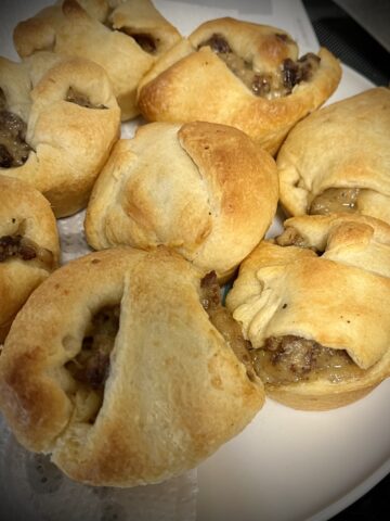 Plate has been feels with sausage gravy crescent rolls they have a nice golden to St on the rolls see little bits of gravy sticking out