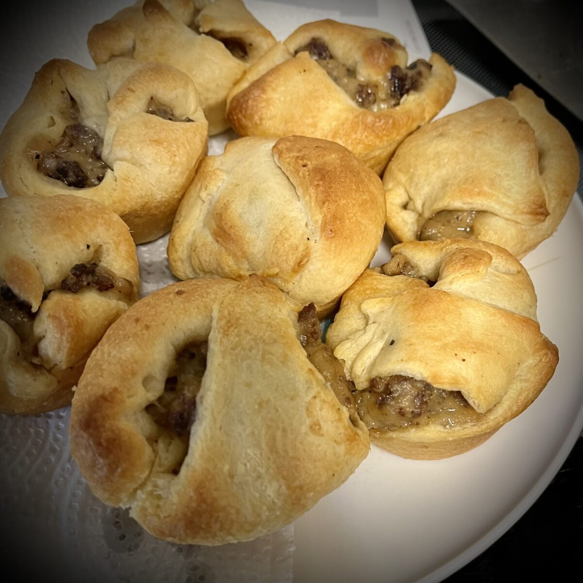 Plate has been feels with sausage gravy crescent rolls they have a nice golden to St on the rolls see little bits of gravy sticking out
