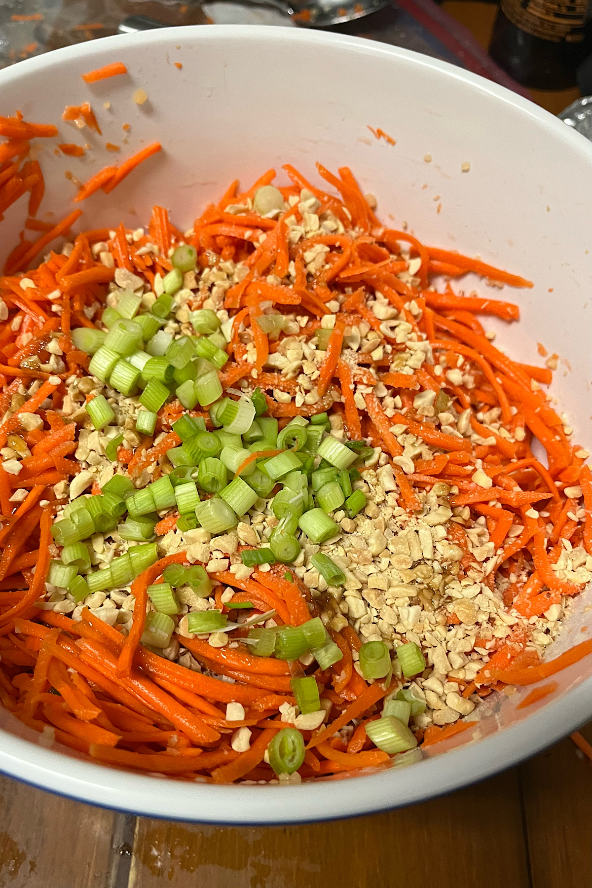 Green onions and peanut sit on the shreades carrots