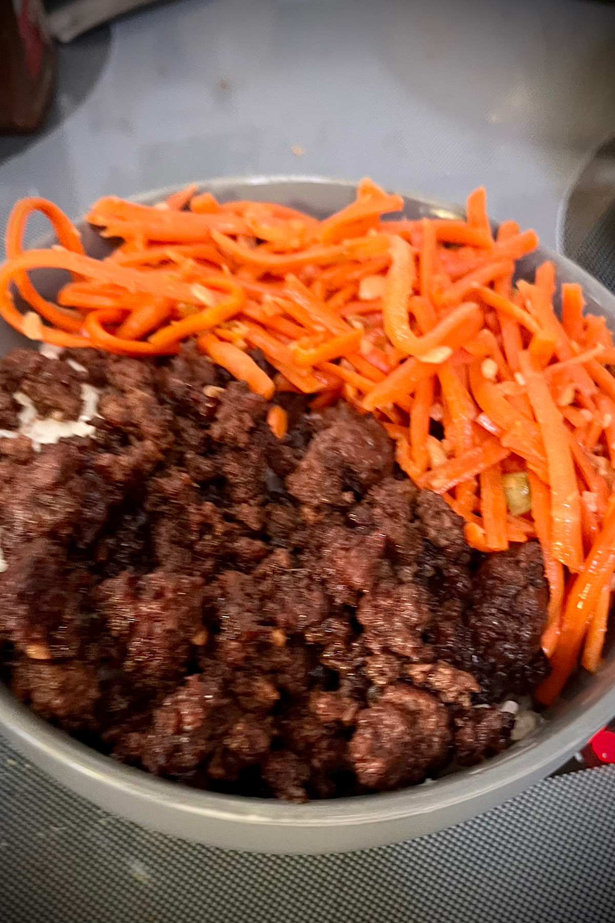 Gonna be sitting in bed rice along with some carrots to them about half a bowl that you can see the bowl is gray