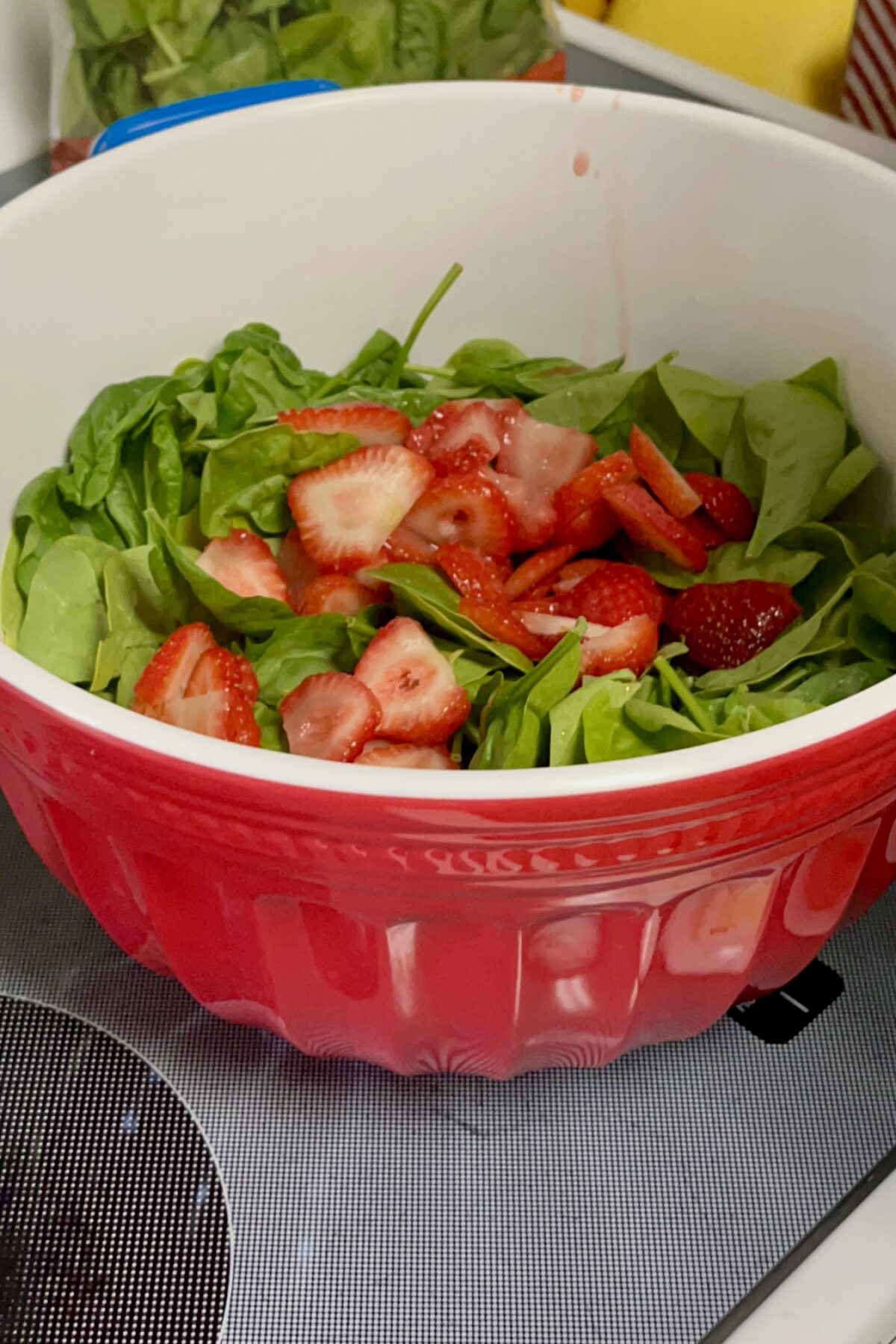 About half of in a large bowl strawberry sooting on top sliced
