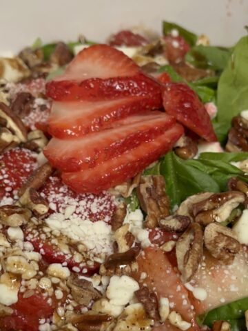 Easy strawberry spinach salad with feta cheese, pecans, and balsamic dressing served in a large bowl.
